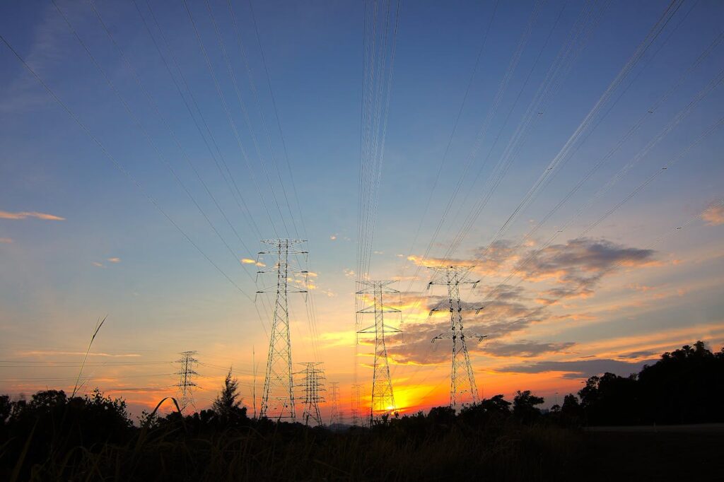pexels-photo-171428 Silhouette of power lines against a dramatic sunset sky in a rural landscape.